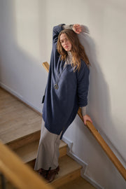 Person wearing a blue tunic on a staircase