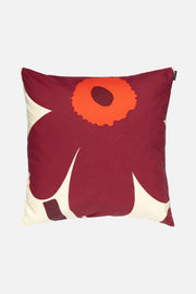 Decorative pillow with a red flower design on a white background