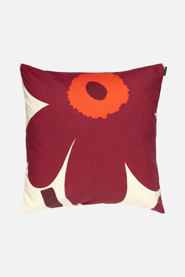 Decorative pillow with a red flower design on a white background